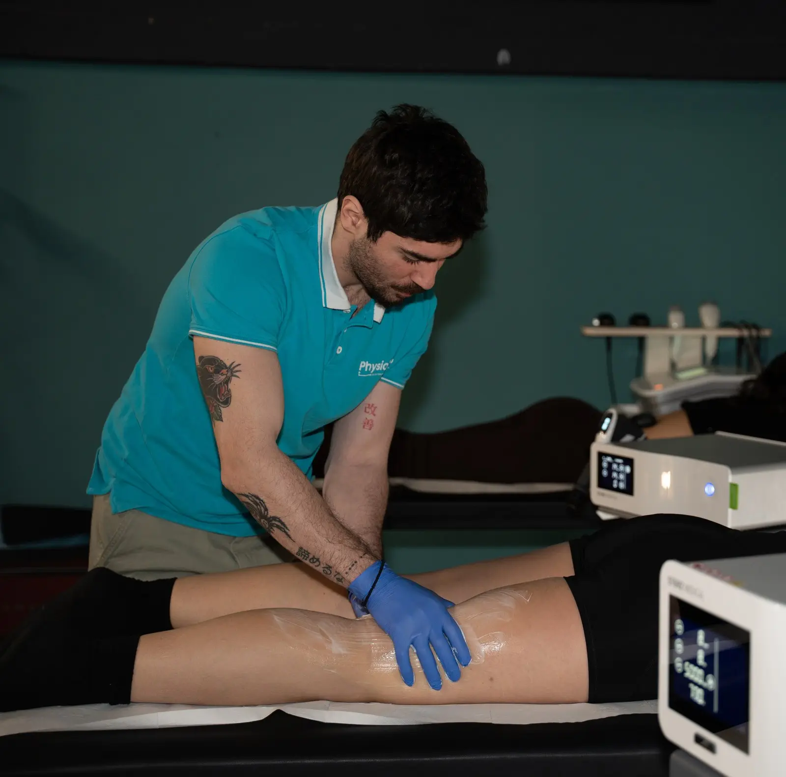 PhysioHub-ის ფიზიოთერაპევტი პაციენტს მაგნიტოთერაპიის აპარატით მკურნალობას უტარებს კლინიკაში